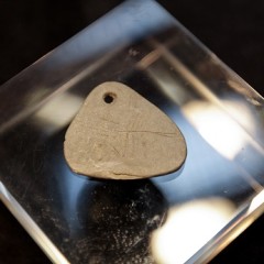 The 11,000 year old engraved shale pendant discovered by archaeologists during excavations at the Early Mesolithic site at Star Carr in North Yorkshire. Image taken at the Yorkshire Museum, York. Credit: Suzy Harrison