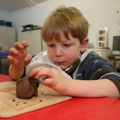 Young boy moulds clay at the Yorkshire Museum