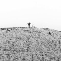 Blurry black and white image of man on a hill
