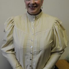 Woman in Victorian style cream blouse with large sleeves