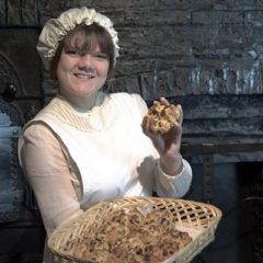 Woman in Victorian clothing with basket of hot cross buns