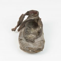 A child's leather shoe. The shoe is very worn.