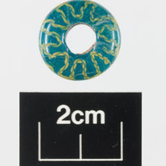 A 2cm blue circular glass bead with a yellow pattern running through it.