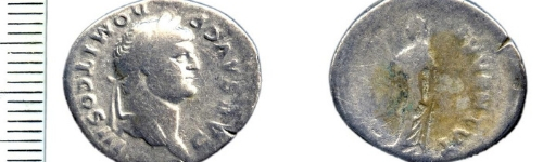 The front and back of a silver Roman coin. The back of the coin slightly worn away.