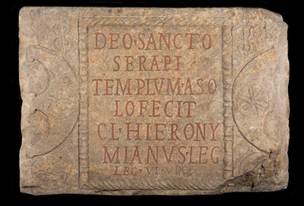 A brown slab with some ancient text inscribed on it.