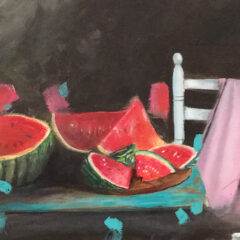 Watermelons are cut up on a blue table. A white chair has a pink scarf thrown over it.