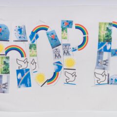 A handmade sign that says HOPE made of rainbows and signs of peace